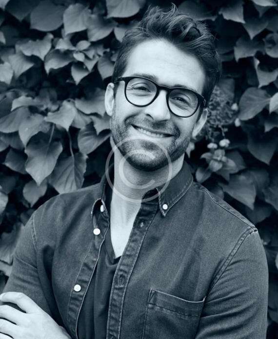 Portrait of a smiling man in glasses and denim shirt