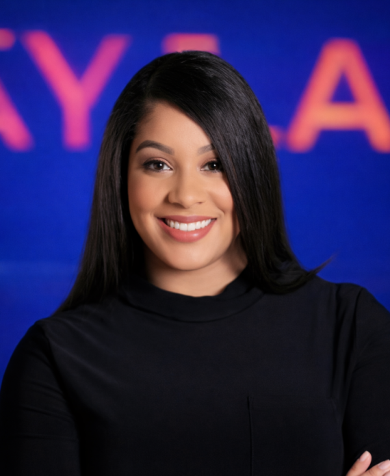 Portrait of a woman in a blazer in front of a Dizplay banner