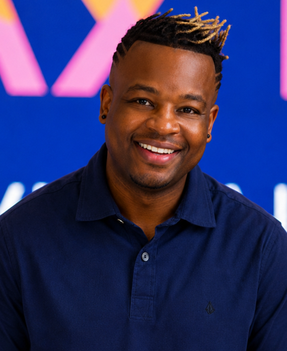 Headshot of a smiling man in front of an LED backdrop