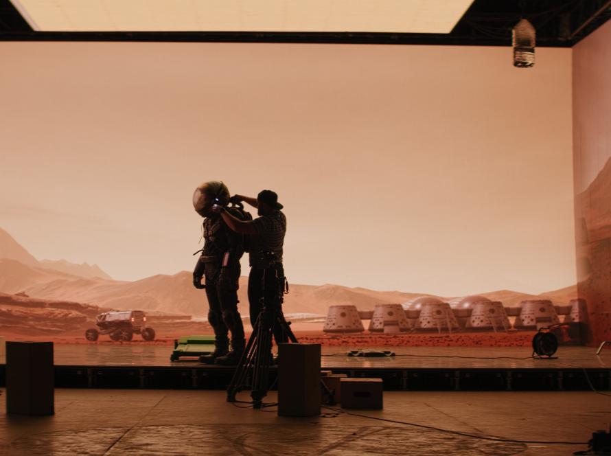Silhouettes in front of a large glowing LED screen